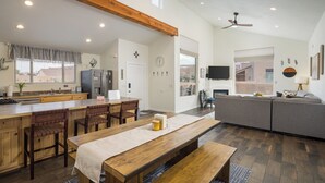 A spacious living area with a wooden bench, a sofa, and a dining table with chairs. - Slickrock Sanctuary (Moab)