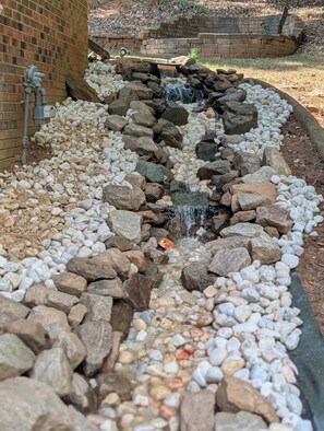 A small waterfall feature surrounded by a variety of rocks and pebbles.