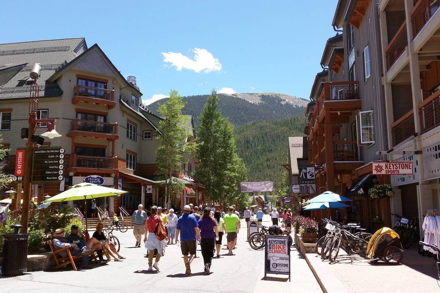 A busy street with buildings, a sign for Keystone Clinics, and bicycles.