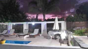 Alberca techada, alberca al aire libre y sombrillas en la alberca