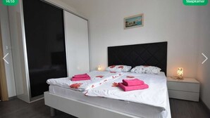 A hotel room with a bed, a nightstand, a painting on the wall, and a sliding door. - Apartment Barbara  in Okrug Gornji (Okrug Gornji)