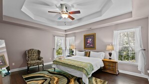 A bedroom with a bed, a chair, a nightstand, a lamp, and a window with curtains. - Near Downtown Cary and Raleigh - 5 room King beds, walking distance to Bond Park (Cary)