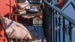 Un balcon avec une table, des chaises et une vue sur la mer.