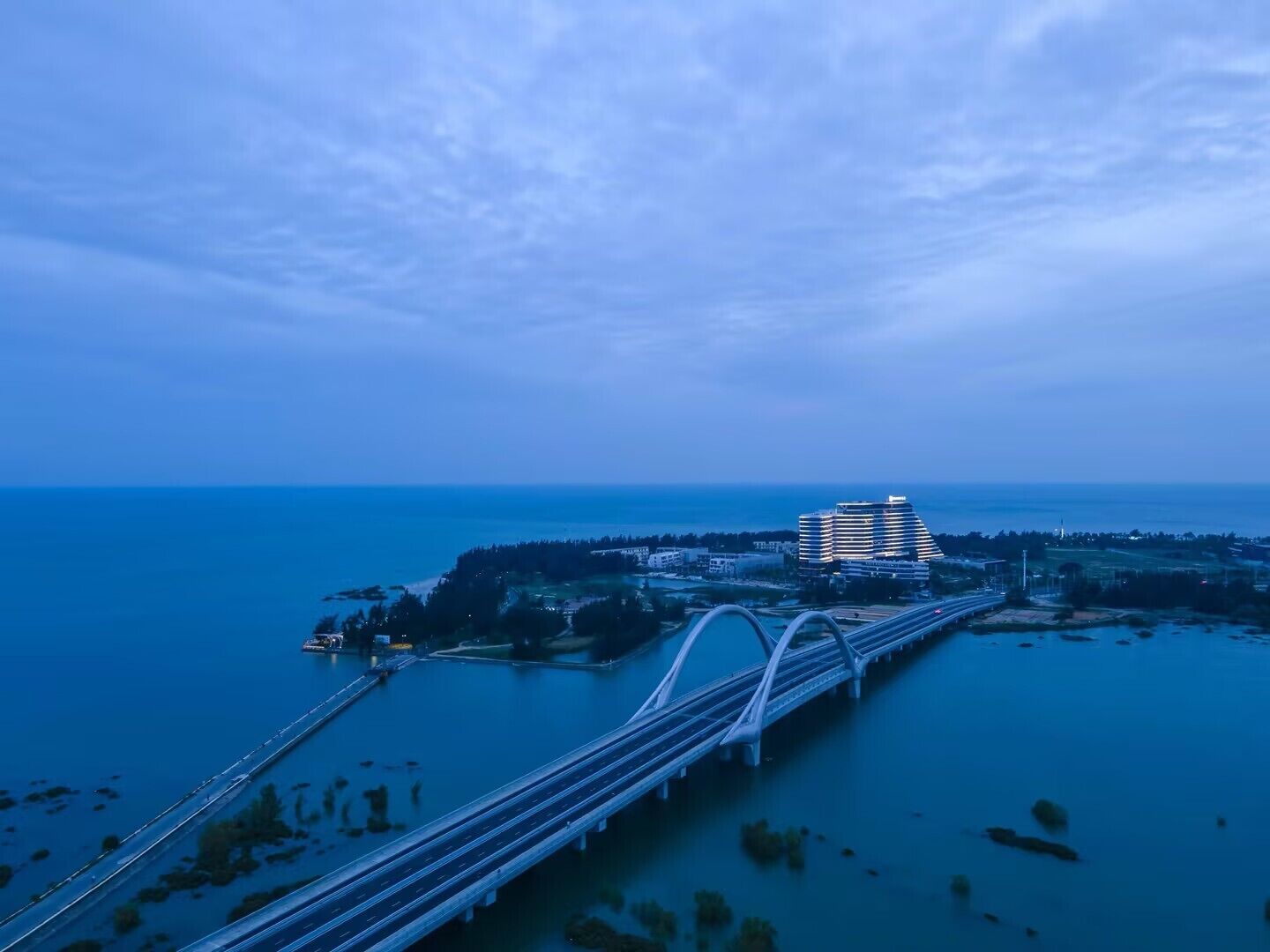 Un puente cruza un cuerpo de agua, con un paisaje urbano al fondo.