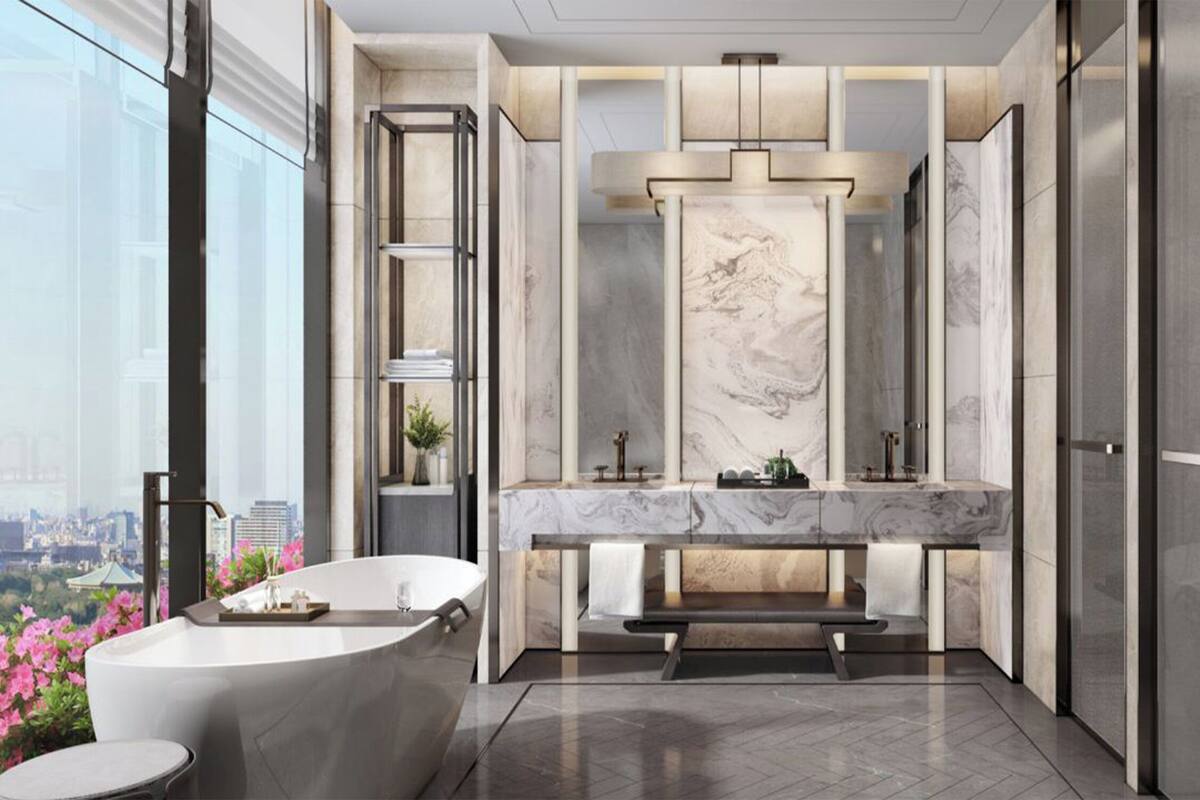 A modern bathroom with a marble vanity, a freestanding bathtub, and a city view.