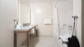 Une salle de bain moderne avec un lavabo, un miroir et un espace douche.