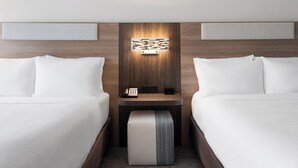 A hotel room with two beds, a bedside table with a phone and a small speaker, and a wall-mounted light fixture. - Holiday Inn Express & Suites Meridian I 20 by IHG (Meridian)