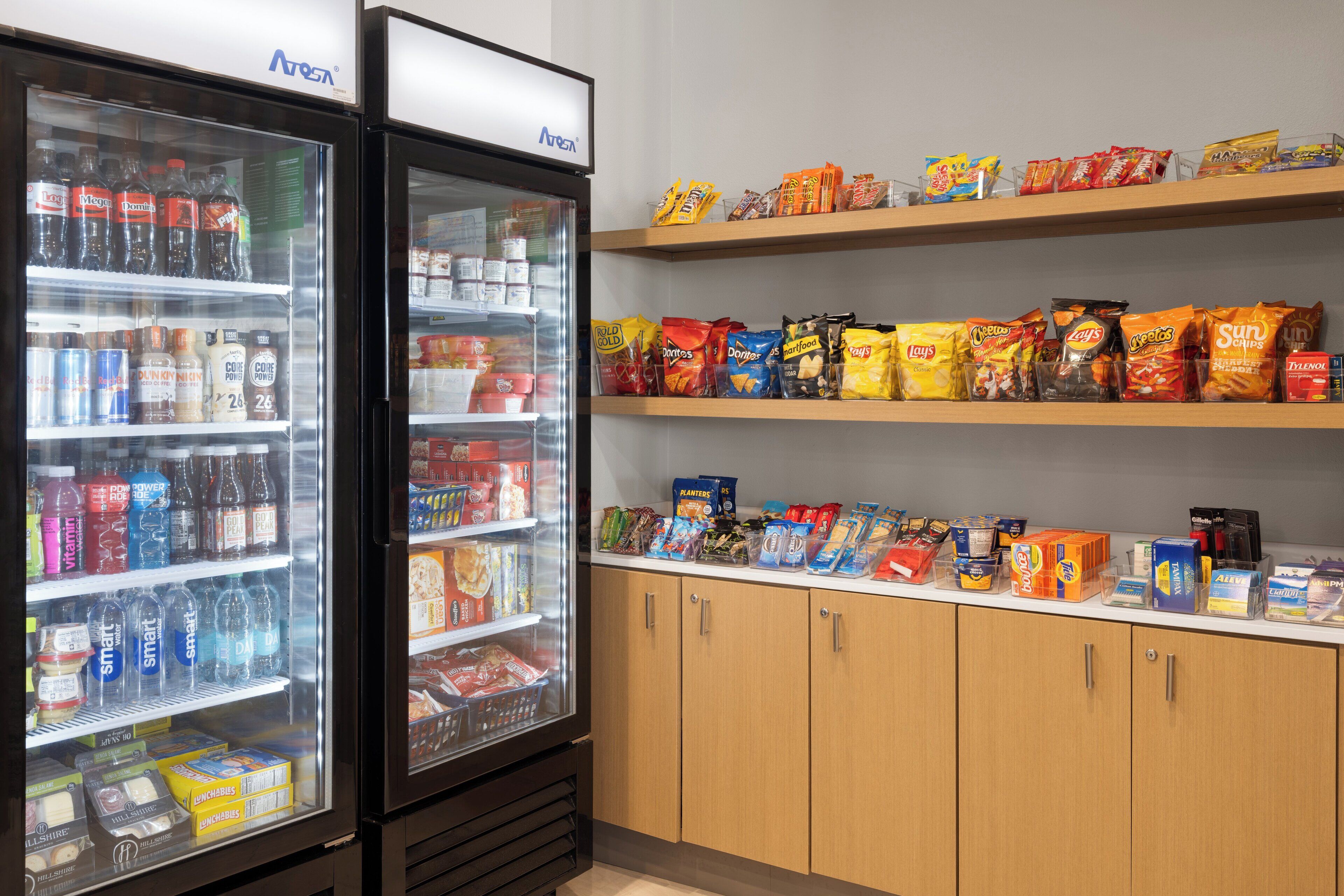 A refrigerated beverage display and snack shelves in a store.