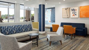 A modern lounge area with a sofa, armchairs, and a coffee table. - Holiday Inn Express & Suites Meridian I 20 by IHG (Meridian)
