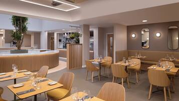 A modern restaurant interior with wooden tables and chairs, a central bar area, and a large potted plant.