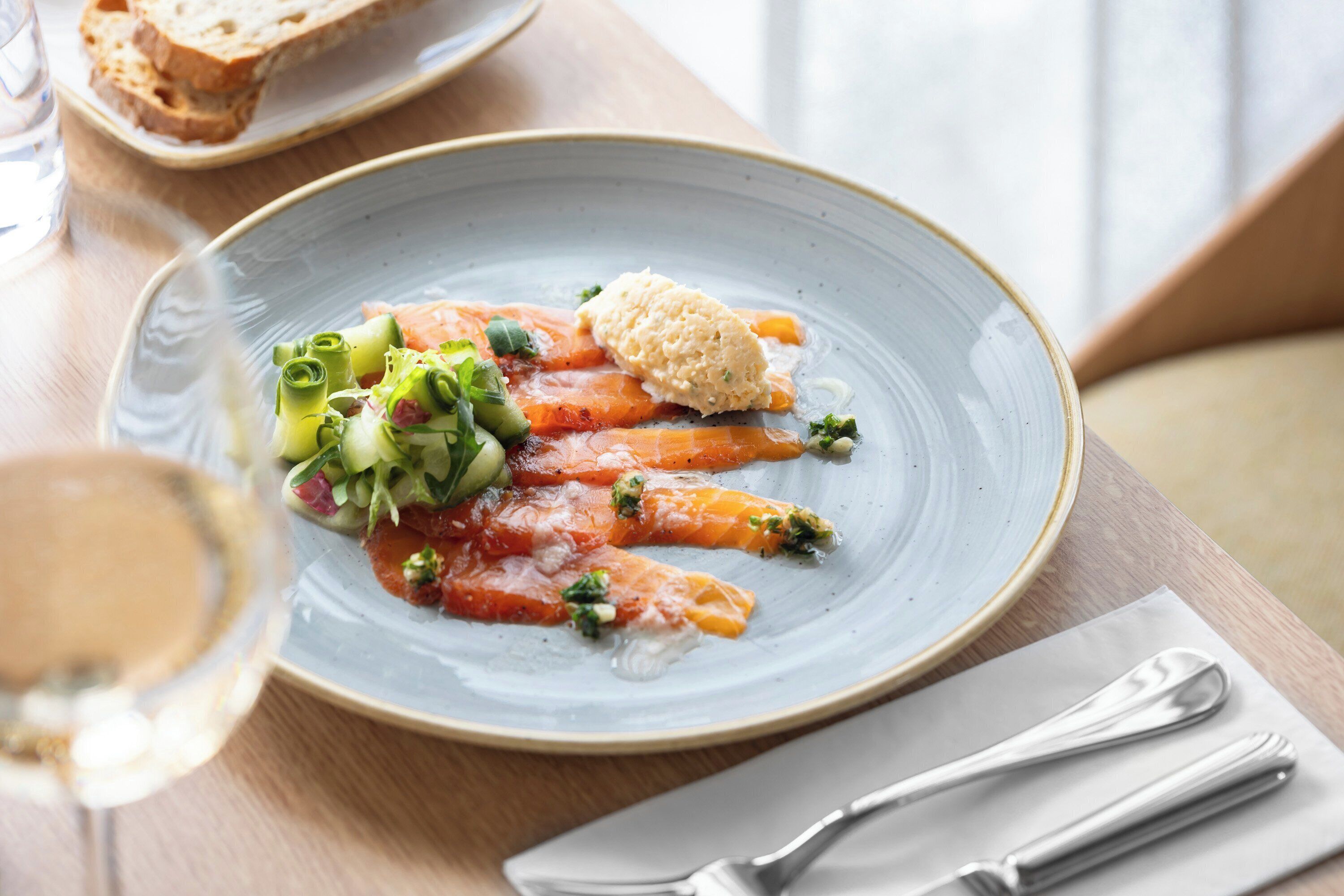 A plate of food with vegetables and a small piece of bread on a table.