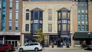 A building with a sign for office space, a corner entrance, and a storefront with a Christmas display.
