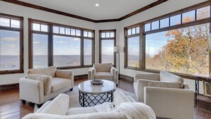 A spacious living room with a large window, a round coffee table, and multiple sofas. - The Lodge in Mentone.  (Mentone)