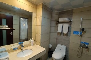 A hotel bathroom with a sink, mirror, toilet, and shower. - Fuhua Hotel (Pingwu)