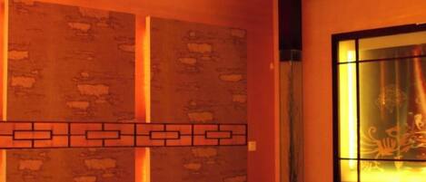 A room with a patterned wall, a decorative light fixture, and a window with a view.
