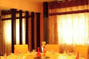 A dining table set with chairs, a vase, and glassware. - Fuhua Hotel (Pingwu)