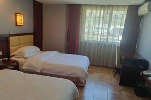 A hotel room with two beds, a desk, a chair, and a window with curtains. - Fuhua Hotel (Pingwu)