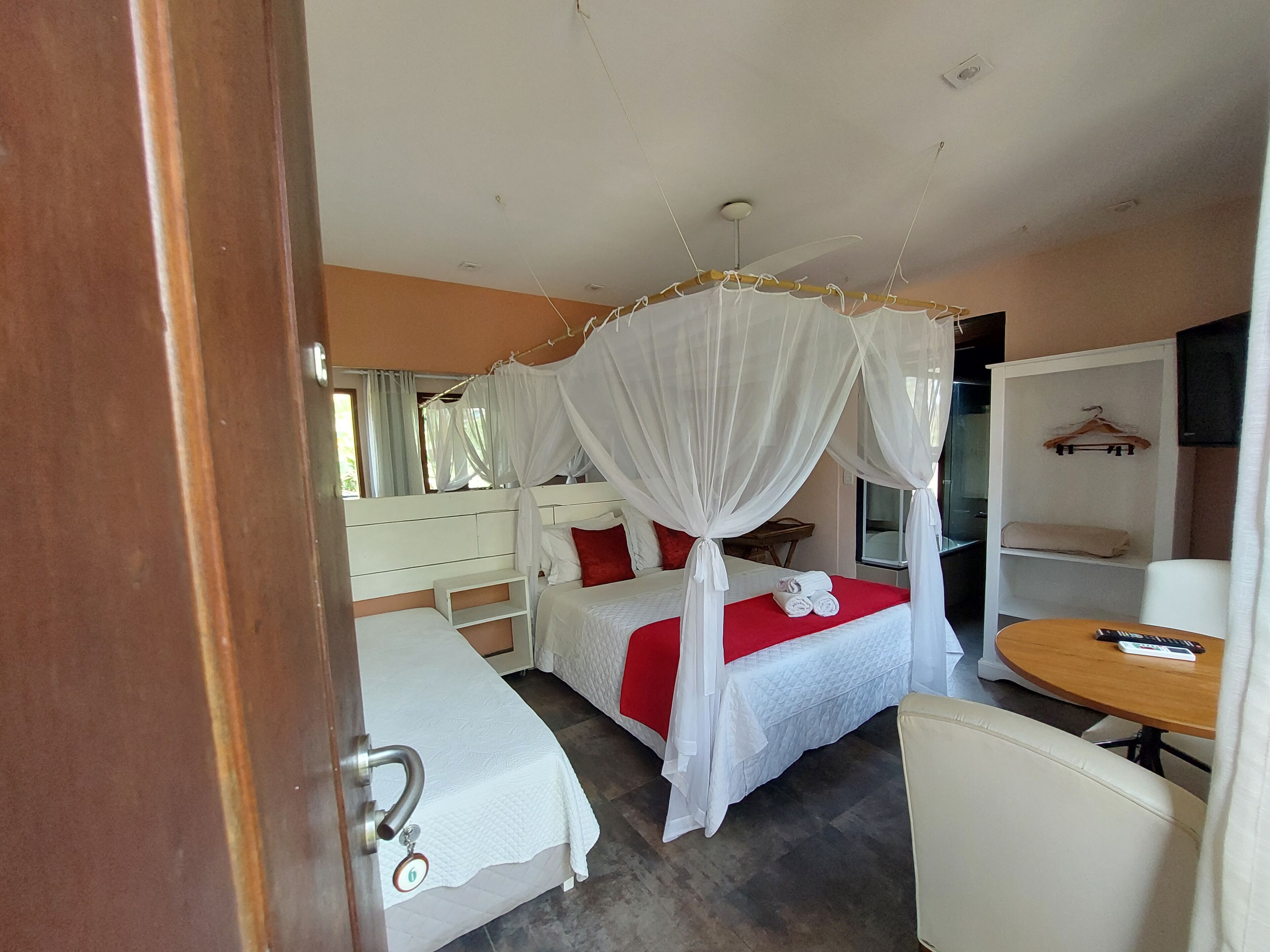 A bedroom with a bed, a bedside table, a chair, and a wardrobe.