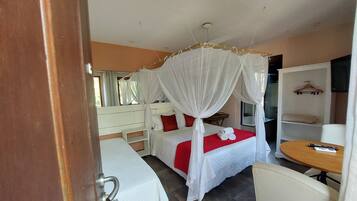 A bedroom with a bed, a bedside table, a chair, and a wardrobe.