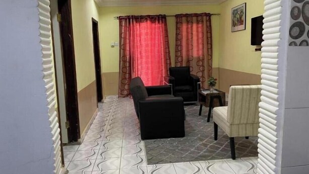 A hallway with a patterned floor, a black armchair, a beige armchair, and a small table with a vase. - Apartment with View and Balcony B (Kunkajan-Jataya)