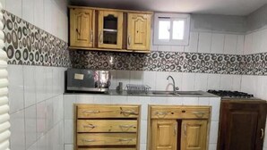 A kitchen with wooden cabinets, a microwave, and a gas stove. - Apartment with View and Balcony B (Kunkajan-Jataya)