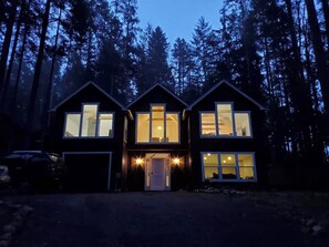 Ein zweistöckiges Haus mit vielen Fenstern, einer Garage und einer Auffahrt.