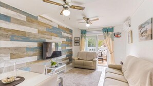 A living room with a TV, two sofas, a coffee table, and a ceiling fan. - Orihuela Costa, Sleeps 6 With Roof Terrace & Pool (Orihuela)