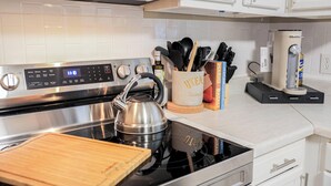 A modern kitchen with stainless steel appliances, a kettle, and a wooden cutting board. - Charming 3-bedroom house in fabulous East Point with AC, WiFi (East Point)