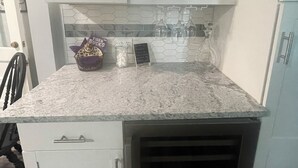 A kitchen with white cabinets, a granite countertop, and a built-in wine cooler. - IT’S FOOTBALL TIME AT THE HIDDEN TIGER! (Baton Rouge)