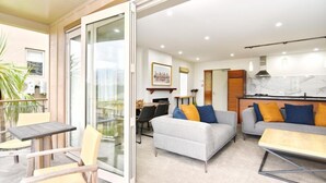 A modern apartment with a balcony, a dining area, a living room with sofas, and a kitchen. - High Country Villa 250-Luxury Villa in Terrace Downs (Christchurch)