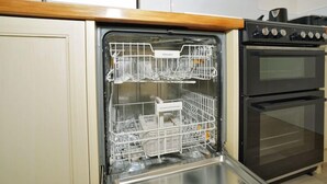 An open dishwasher with multiple racks and a label that reads "Miele." - Narrows Hideaway-Rural retreat near Hamilton Airport (Christchurch)