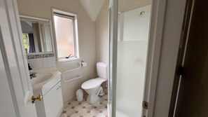 Un baño pequeño con inodoro, lavabo y ducha.