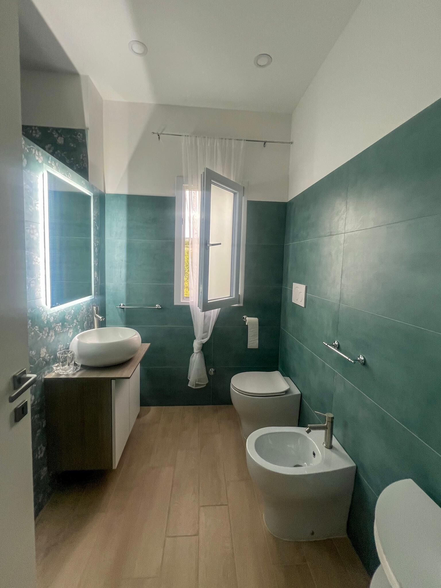 Un baño con inodoro, bidé y lavamanos.