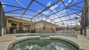 Une piscine extérieure couverte offrant une vue dégagée sur le ciel et les palmiers en arrière-plan.