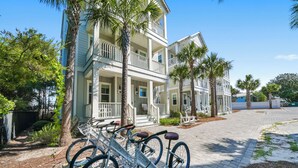 A two-story building with a balcony and a bicycle parked in front. - Sandy Bottoms | Inlet Beach Home 5 Minute Walk to Beach & Private Community Pool (Inlet Beach)