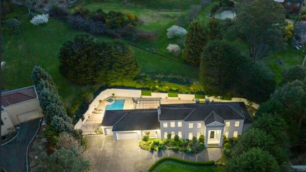 A large, two-story house with a swimming pool, surrounded by well-maintained lawns and trees. - StayAU Expansive 7BR Villa Warrandyte (Warrandyte)