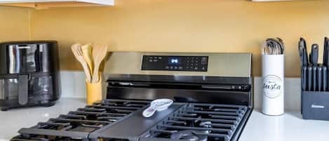 Une cuisine équipée d’une cuisinière, d’une machine à café et d’un bloc à couteaux.