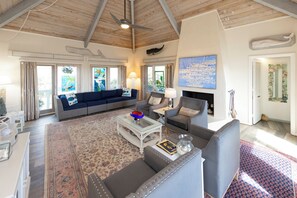 Amplia sala de estar con techo alto, chimenea y un gran ventanal con vistas.