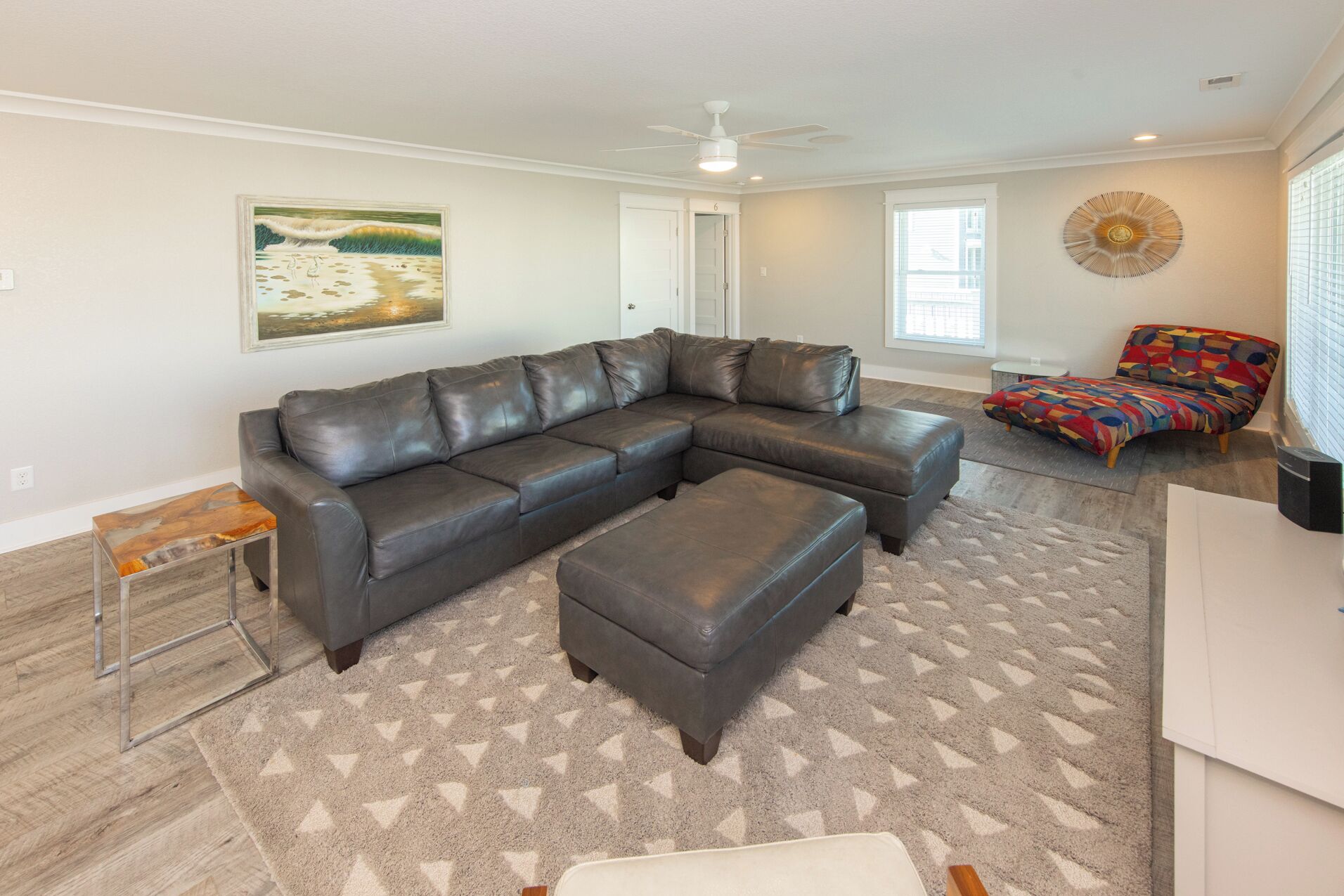 A modern living room with a sectional sofa, a colorful armchair, a coffee table, and a rug.