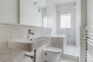 Ein modernes Badezimmer mit Waschbecken, Toilette und Duschbereich.