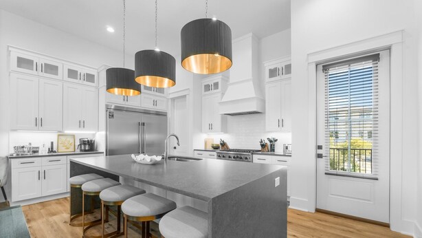 A modern kitchen with white cabinets, a large island with bar stools, stainless steel appliances, and pendant lighting. - 7-bedroom/ 7-bathroom house; Private pool; Golf cart included (Santa Rosa Beach)