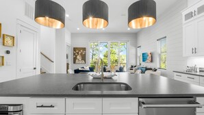 A modern kitchen with a large island, stainless steel appliances, and pendant lighting. - 7-bedroom/ 7-bathroom house; Private pool; Golf cart included (Santa Rosa Beach)