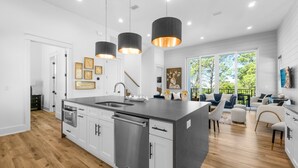 A modern kitchen with a large island, stainless steel appliances, and pendant lighting. - 7-bedroom/ 7-bathroom house; Private pool; Golf cart included (Santa Rosa Beach)