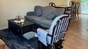 Un salon avec un canapé, une table à manger et un ventilateur de plafond.