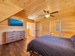 A wooden cabin bedroom with a bed, dresser, and a ceiling fan. - 6BR Mountain Lodge Hot Tub, Game Room, Groups (Banner Elk)