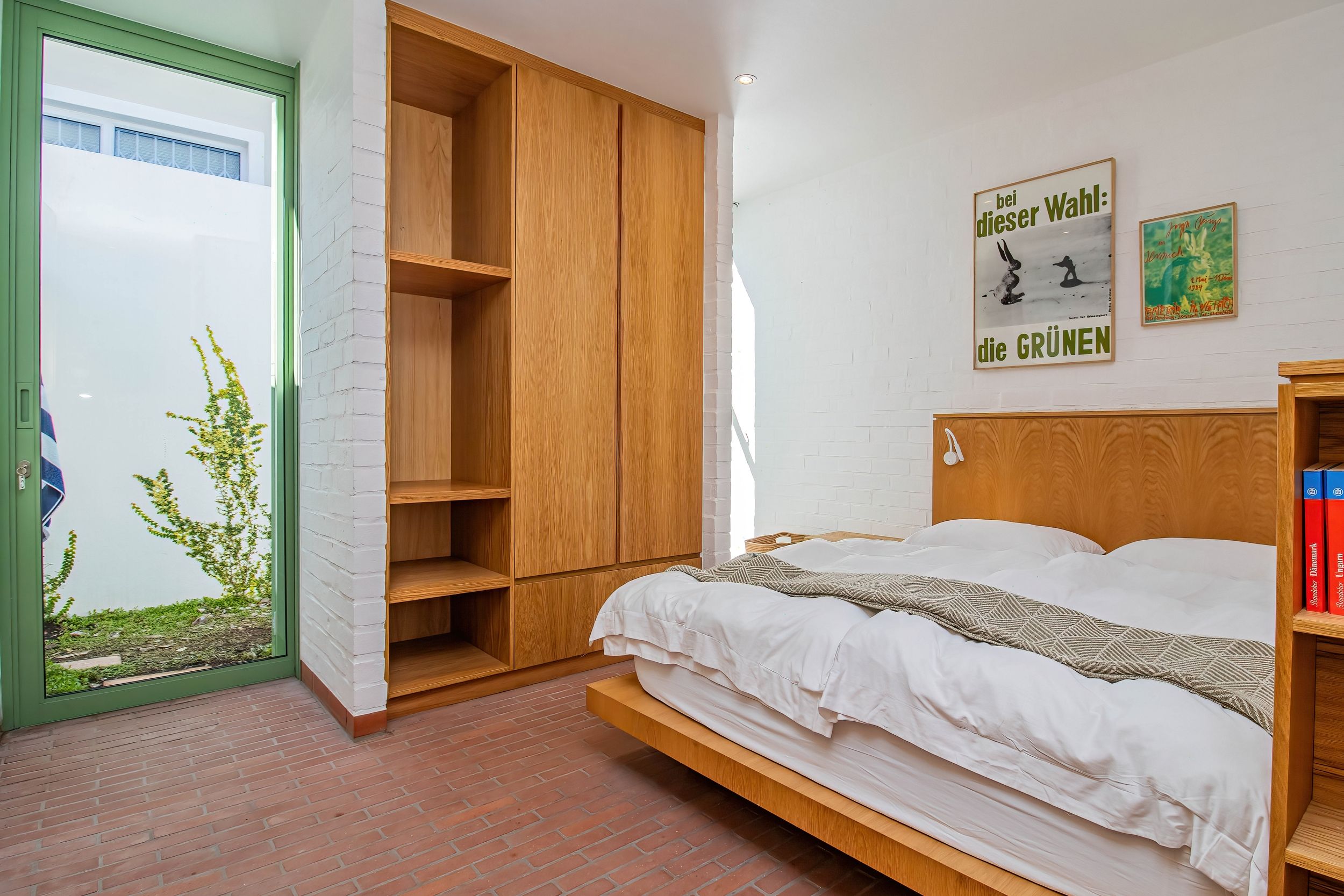 Une chambre à coucher avec un lit, une armoire en bois et une fenêtre donnant sur un paysage verdoyant.