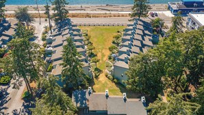 A coastal residential area with a marina, houses with sloped roofs, and a clear view of the sea. - The Beach Retreat-Stylish 2-bedroom view condo in Birch Bay  (Blaine)