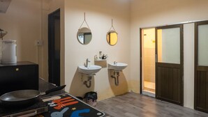 Ein Badezimmer mit zwei Waschbecken, einem Spiegel, einer Dusche und einer Tür zu einem weiteren Raum.