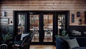A cozy interior with wooden paneling, a black-framed glass door, and a seating area with a sofa and chairs. - Ship Inn Stanley (Stanley)