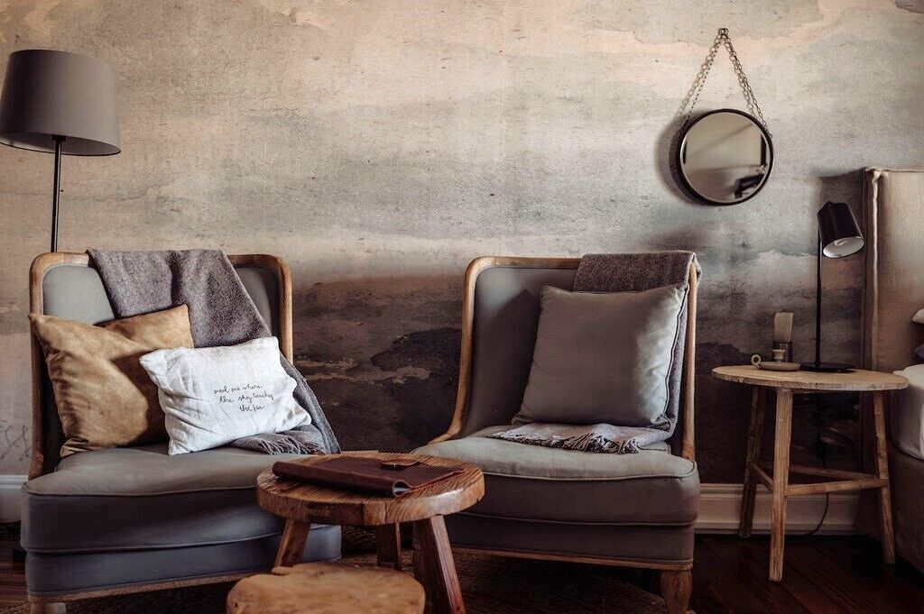 A cozy seating area with two cushioned chairs, a small round table, and a lamp.